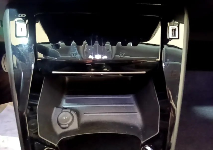 Vue rapprochée de la console centrale noire du Peugeot 2008 blanc, avec prise 12V et ports USB visibles.