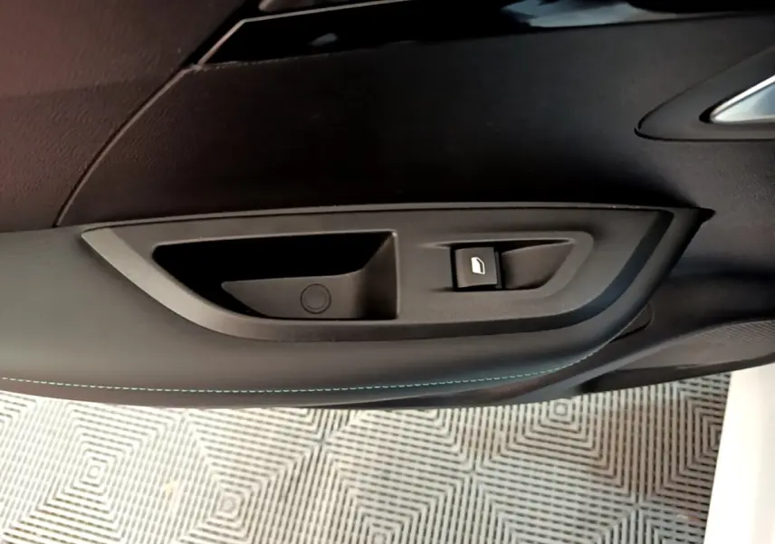 Poignée intérieure de porte côté droit du Peugeot 2008 blanc, avec bouton de verrouillage visible.