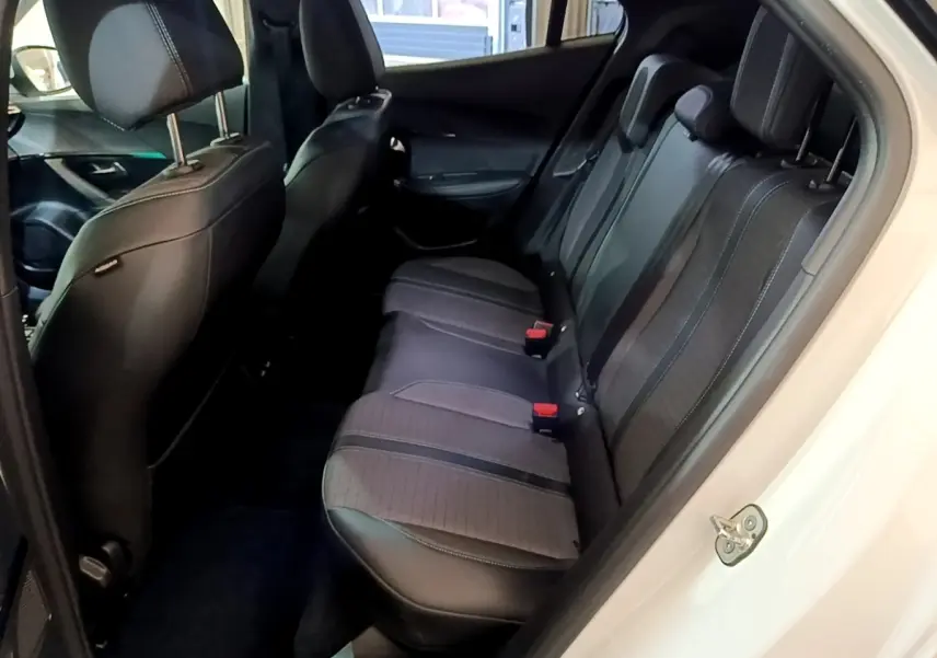 Vue intérieure côté droit montrant la banquette arrière noire et grise du Peugeot 2008 blanc, version BlueHDi 130 Allure Pack.