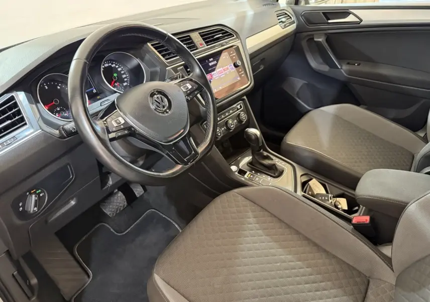 Vue intérieure côté conducteur du Volkswagen Tiguan 2020, volant cuir multifonctions et console centrale avec écran tactile.