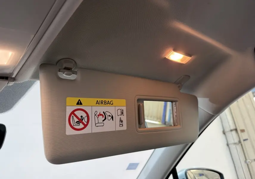 Désolé, l'image montre uniquement un pare-soleil intérieur avec miroir et avertissement airbag, sans vue extérieure du Volkswagen Tiguan.