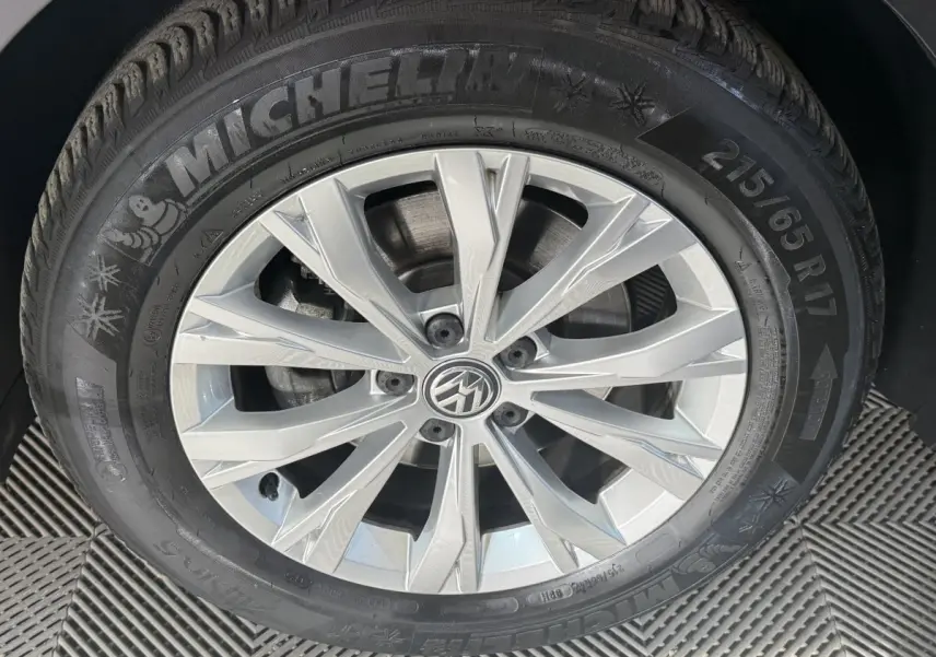 Gros plan sur la jante alliage argentée et pneu Michelin d’un Volkswagen Tiguan gris clair, vue latérale.