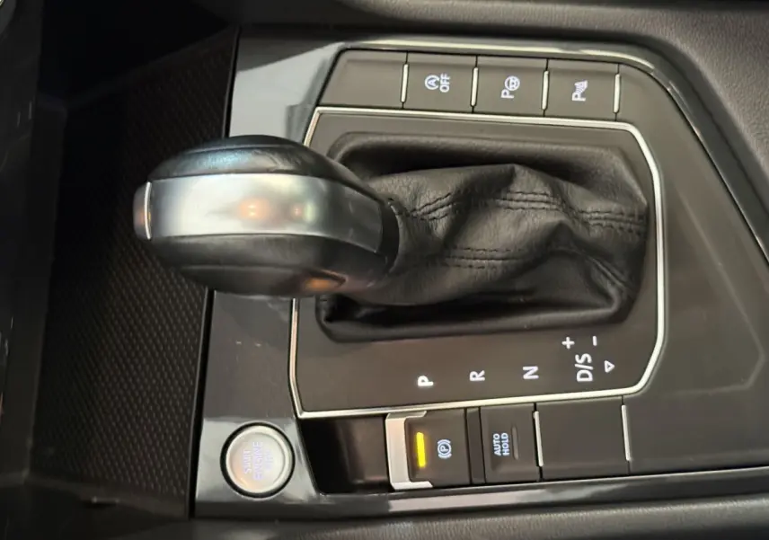 Gros plan sur la console centrale du Volkswagen Tiguan 2020, montrant le levier de vitesse automatique en cuir noir et les boutons de contrôle.