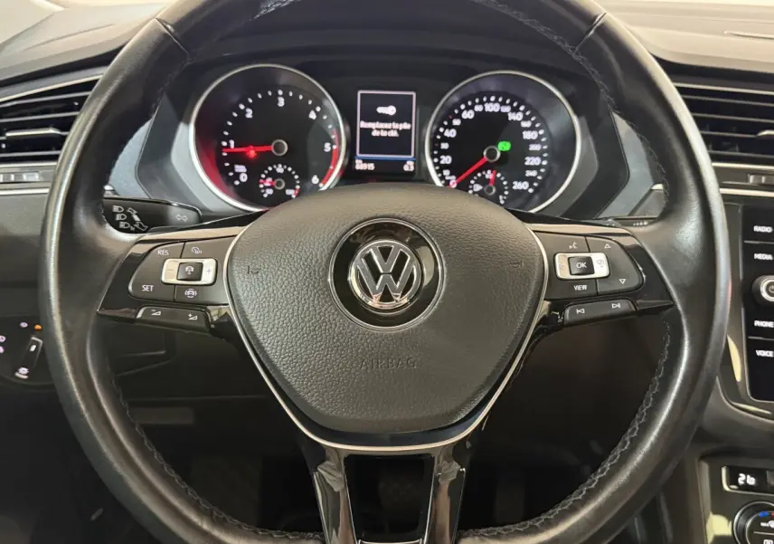 Vue intérieure centrée sur le volant cuir multifonctions noir du Volkswagen Tiguan 2020, avec tableau de bord et écran tactile visibles.