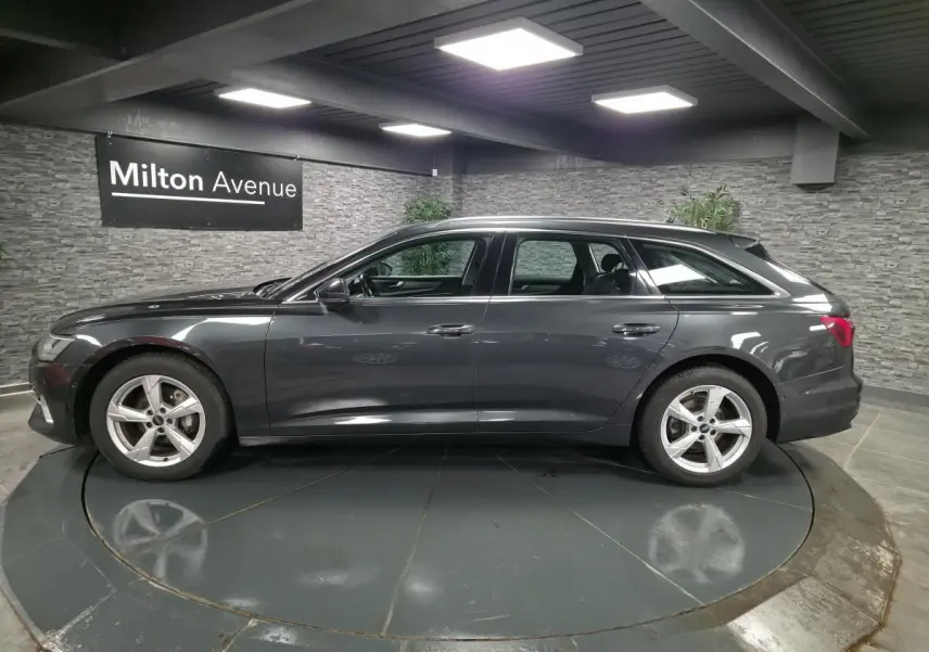 Profil côté gauche d'une Audi A6 Avant gris métallisé 2022 avec jantes 5 branches et toit ouvrant visible.