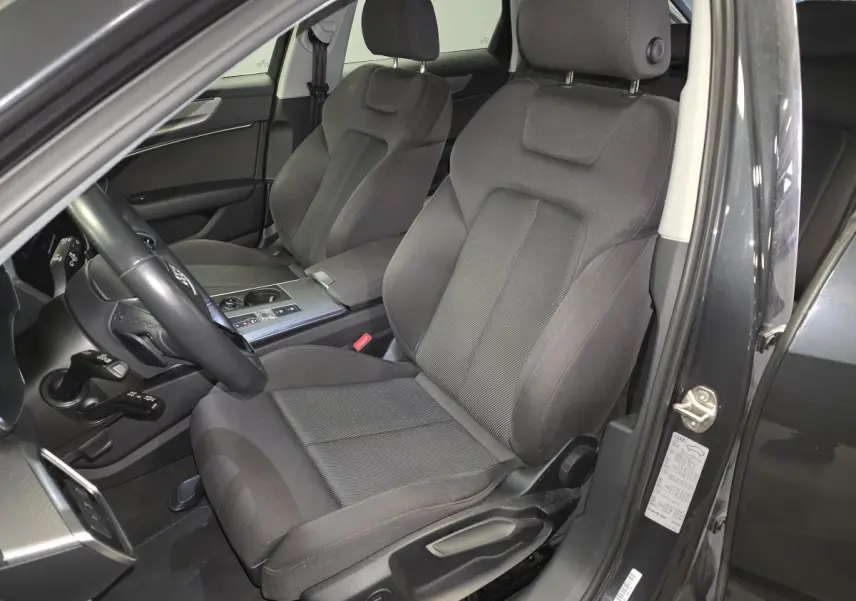 Vue intérieure côté conducteur de l'Audi A6 Avant gris 2022, sièges sport en microfibre noire et console centrale alu brossé.