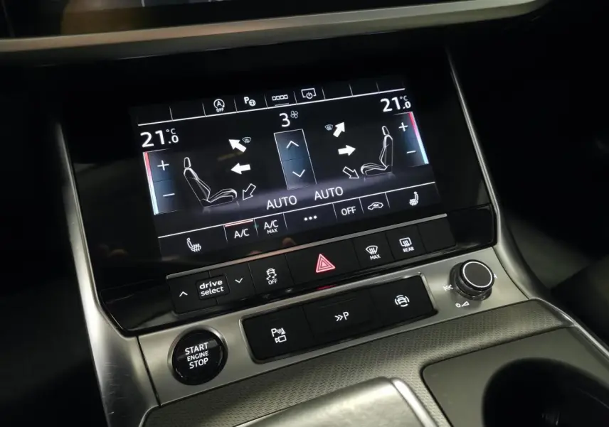 Gros plan sur la console centrale de l'Audi A6 gris, écran tactile affichant la climatisation bi-zone à 21°C.