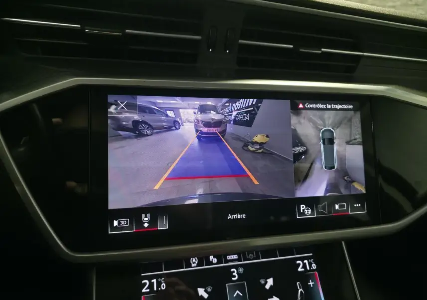 Écran de caméra de recul et vue 360° dans un Audi A6 gris, affichage du système d'assistance au stationnement.