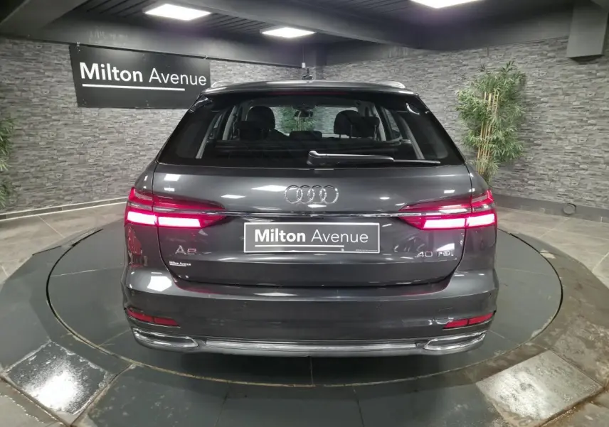 Vue arrière d'une Audi A6 Avant gris métallisé 40 TDI avec feux LED allumés dans un showroom.