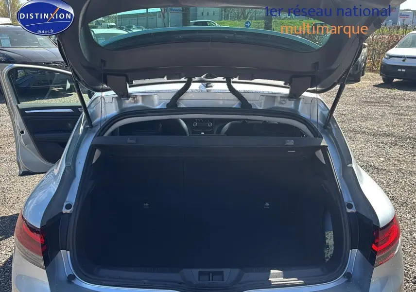 Vue arrière ouverte sur le coffre d’une Renault Mégane IV gris Highland 2023, porte arrière gauche ouverte.