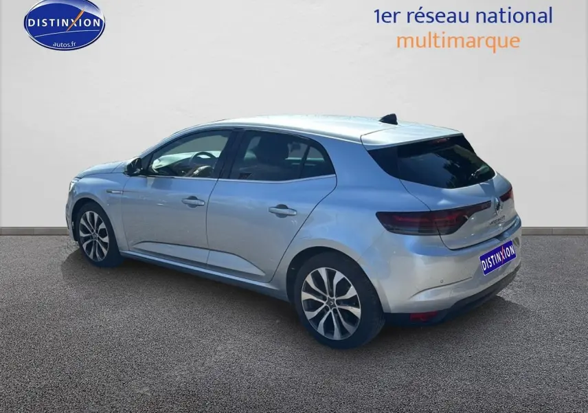 Vue 3/4 arrière droite d'une Renault Mégane IV gris Highland avec jantes alliage et vitres teintées.