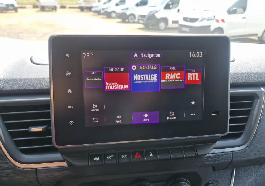 Écran tactile central du Renault Trafic Combi 2026 gris urbain, affichant les stations radio avec commandes en dessous.