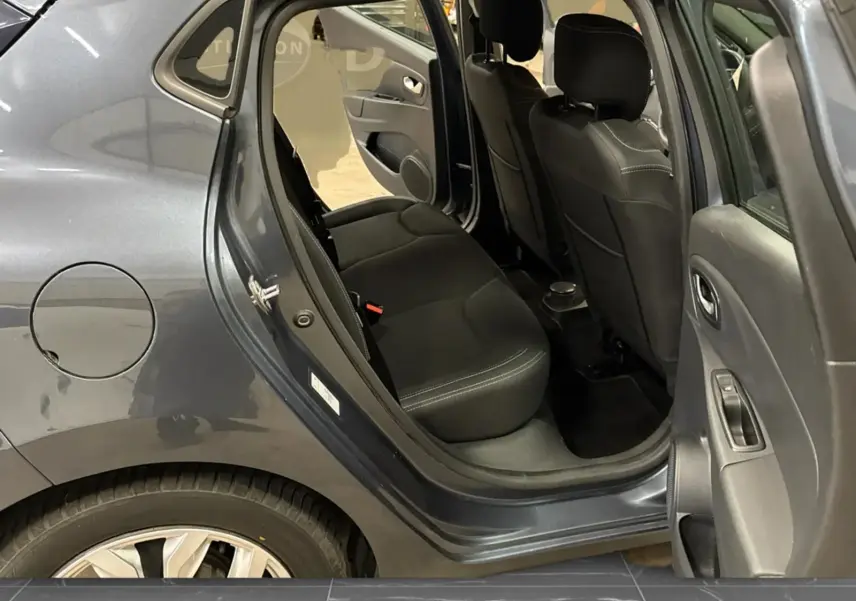 Vue côté gauche arrière de la Renault Clio IV gris foncé métal, porte arrière ouverte dévoilant les sièges arrière en tissu noir.