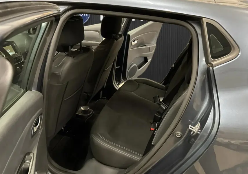 Vue intérieure arrière côté droit de la Renault Clio IV gris foncé métal, montrant les sièges arrière et la portière ouverte.