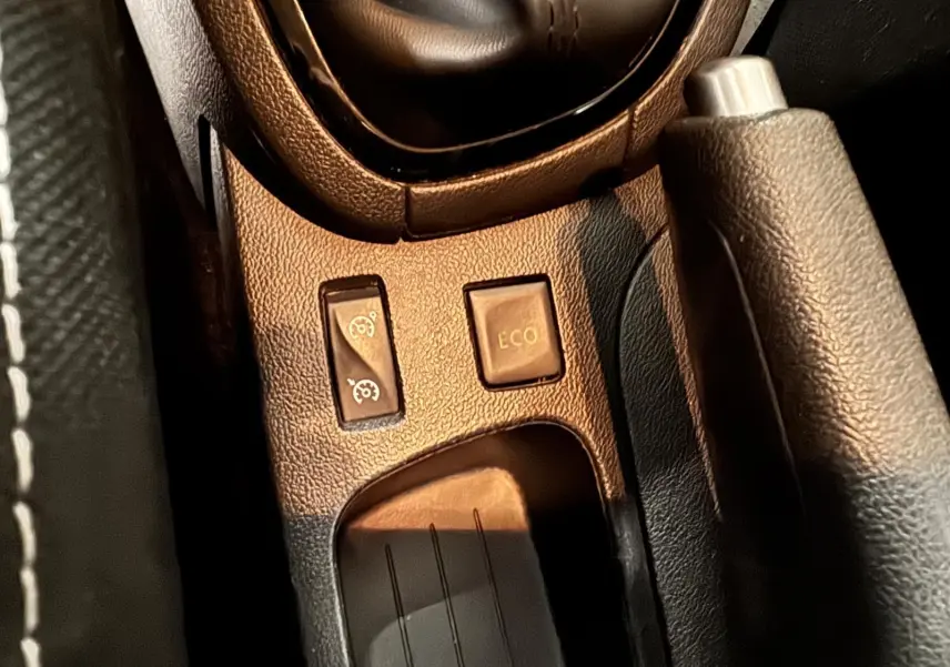 Gros plan sur la console centrale de la Renault Clio IV gris foncé, montrant les boutons de régulateur et mode ECO.