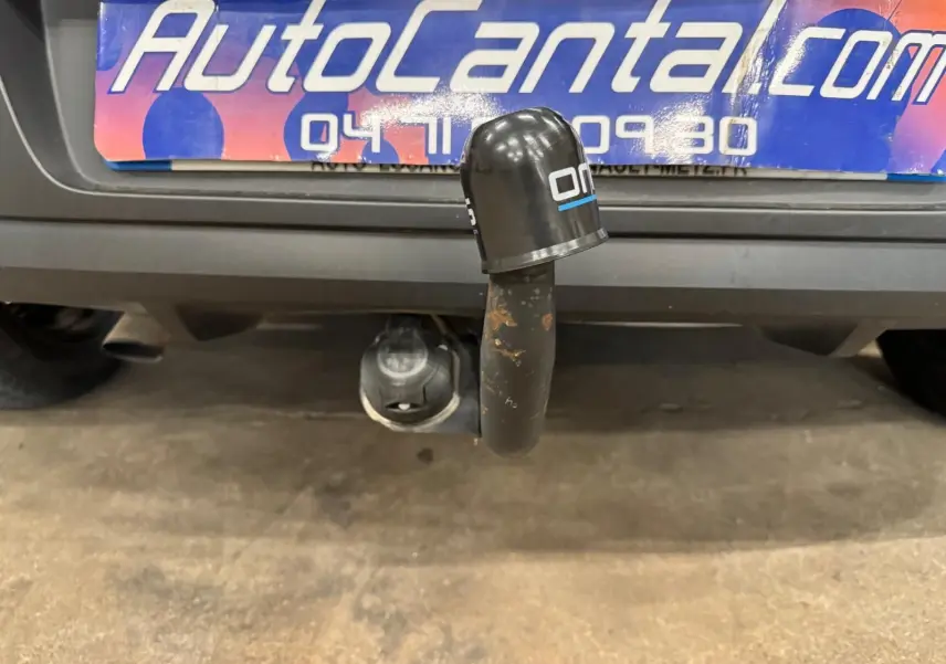 Gros plan sur l'attelage arrière d'une Renault Clio IV gris foncé, avec plaque d'immatriculation partiellement visible.