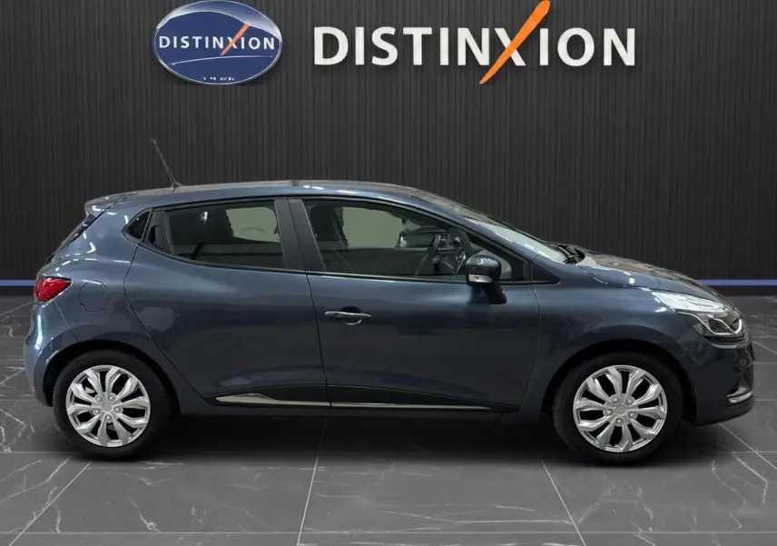 Profil droit d'une Renault Clio IV gris foncé métal, compacte cinq portes, avec jantes alliage et antenne de toit visible.