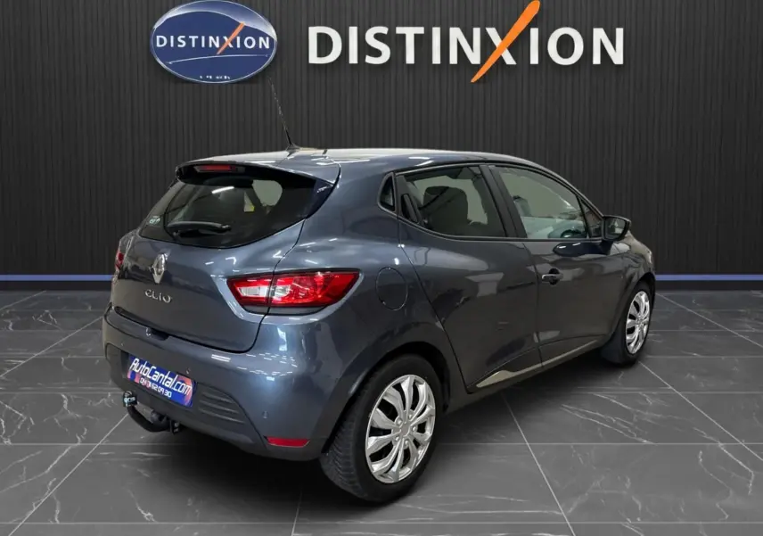 Renault Clio IV gris foncé métal vue 3/4 arrière droit avec attelage et jantes alliage en showroom.