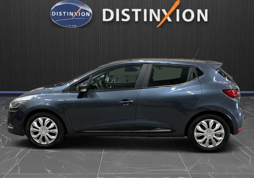 Renault Clio IV gris foncé métal vue de profil côté gauche, stationnée en intérieur avec jantes argentées.