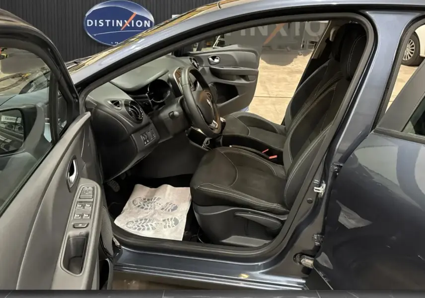 Intérieur côté gauche de la Renault Clio IV gris foncé, avec portes ouvertes et sièges noirs en tissu visibles.