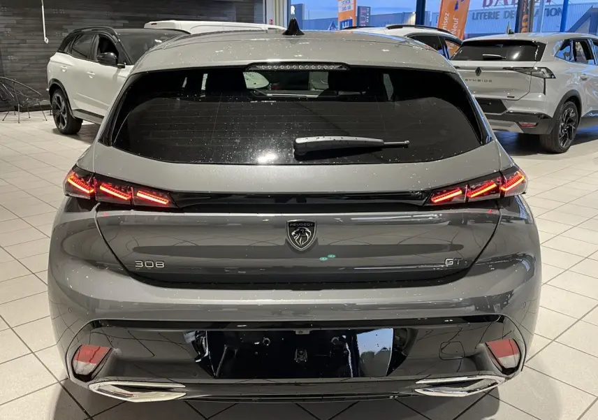 Vue arrière d'une Peugeot 308 GT gris selenium avec feux arrière LED griffés et double sortie d'échappement chromée.