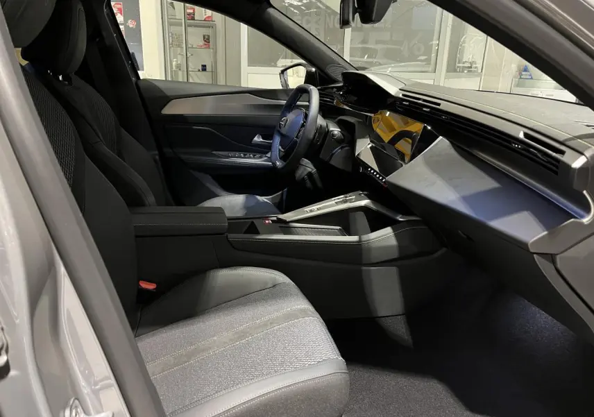 Intérieur avant droit de la Peugeot 308 gris selenium, avec tableau de bord moderne et sellerie tissu/TEP noire.