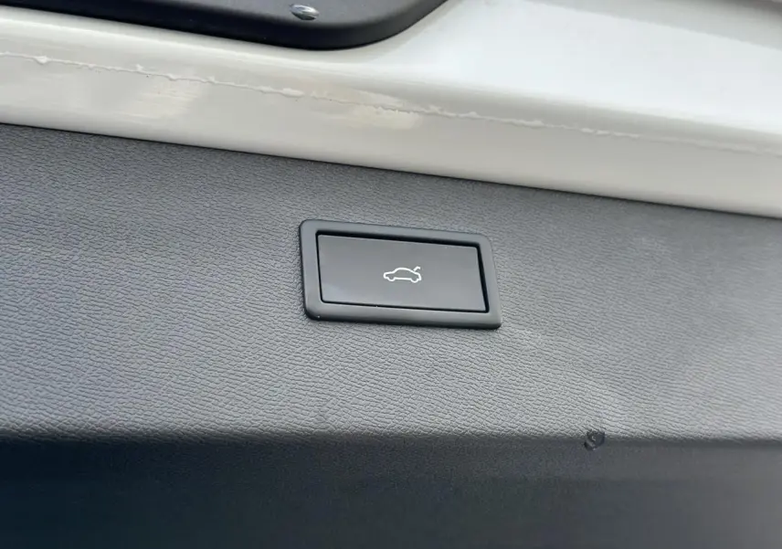 Bouton d'ouverture électrique du hayon sur la garniture intérieure blanche neige du coffre arrière du CUPRA Formentor 2025