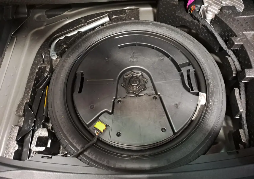 Vue plongeante sur la roue de secours et les outils de coffre d'une CUPRA Leon 2023 Noir Minuit.