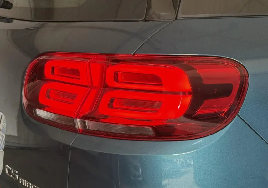 Gros plan sur le feu arrière droit rouge du Citroën C5 Aircross bleu métallisé, avec logo visible sur la carrosserie.