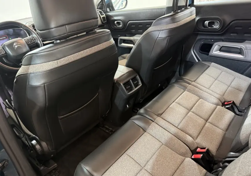 Vue intérieure arrière côté droit du Citroën C5 Aircross 2021 bleu, sièges bicolores tissu et cuir avec console centrale.