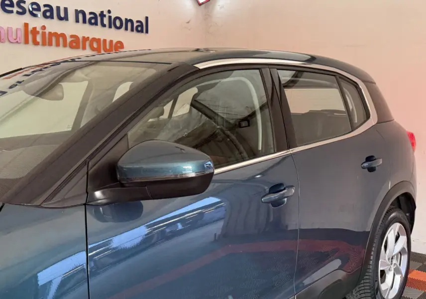 Vue latérale gauche d'un Citroën C5 Aircross bleu métallisé avec rétroviseur électrique et poignées de porte visibles.