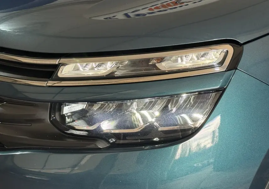 Gros plan sur le phare avant droit LED du Citroën C5 Aircross bleu métallisé, mettant en valeur son design moderne.