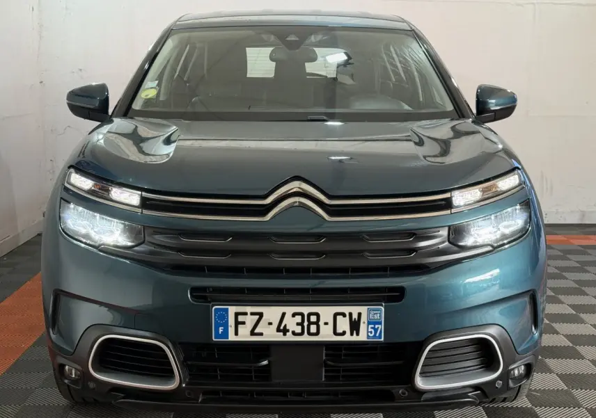 Vue avant d'un Citroën C5 Aircross bleu avec phares LED allumés et calandre chromée distinctive.