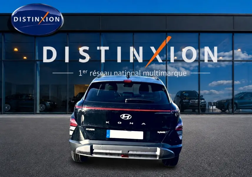 Vue arrière d'un Hyundai Kona noir hybride 2025 avec bande lumineuse LED et logo visible devant une vitrine Distinxion.