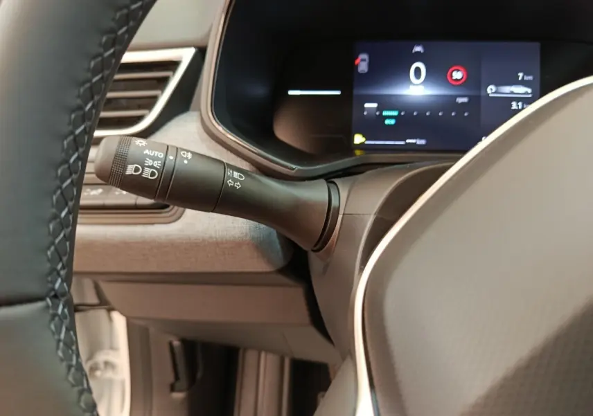 Vue intérieure rapprochée du combiné d’instruments numérique et du commodo d’éclairage de la Renault Clio Evolution TCe 90 2024.