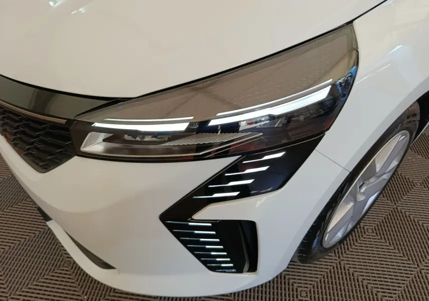 Gros plan sur l'avant droit blanc de la Renault Clio 2024 avec phares LED et détails lumineux distinctifs.
