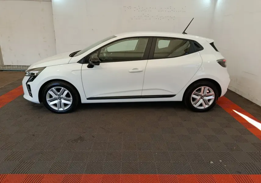 Profil droit d'une Renault Clio blanche 2024 avec jantes alliage et feux arrière LED visibles en intérieur.