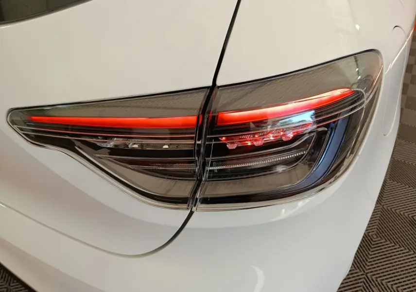 Gros plan sur le feu arrière droit rouge et noir d’une Renault Clio blanche 2024, vue arrière côté droit.