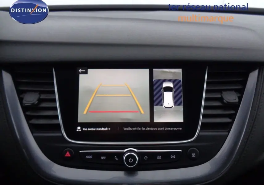 Écran central de l’Opel Grandland X blanc métal montrant la caméra de recul avec guidage et vue 360° sur tableau de bord noir.