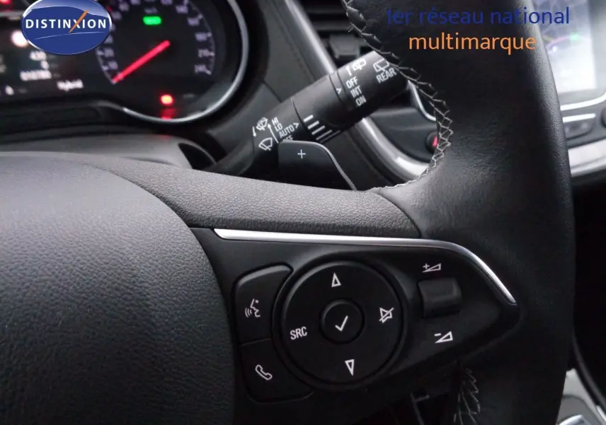 Gros plan sur le volant en cuir noir de l’Opel Grandland X 1.6 Hybrid Turbo, avec commandes multifonctions visibles.