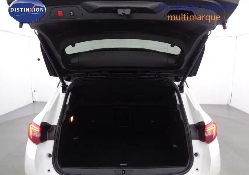 Vue arrière du coffre ouvert d’un Opel Grandland X blanc métal avec feux arrière allumés dans un studio.