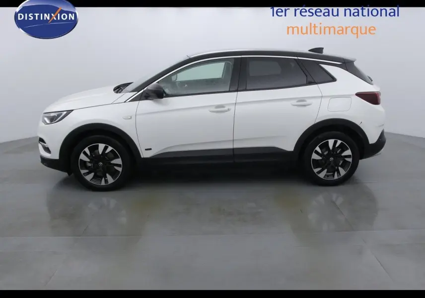 Opel Grandland X blanc métal vu de profil côté gauche, avec jantes bicolores et toit noir contrastant.
