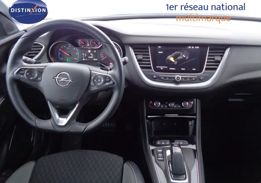 Vue intérieure du poste de conduite de l’Opel Grandland X hybride, avec volant multifonction et écran central tactile.