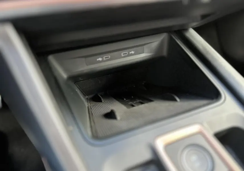 Gros plan sur la console centrale du CUPRA Formentor blanc Neige, mettant en valeur les ports USB et le rangement intégré.