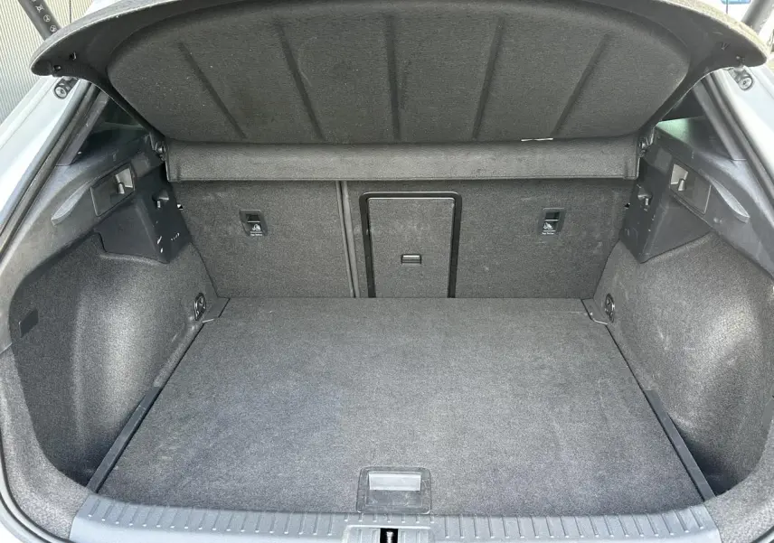 Coffre ouvert vu de l'arrière du CUPRA Formentor blanc Neige, montrant l'espace de chargement et la trappe à skis.