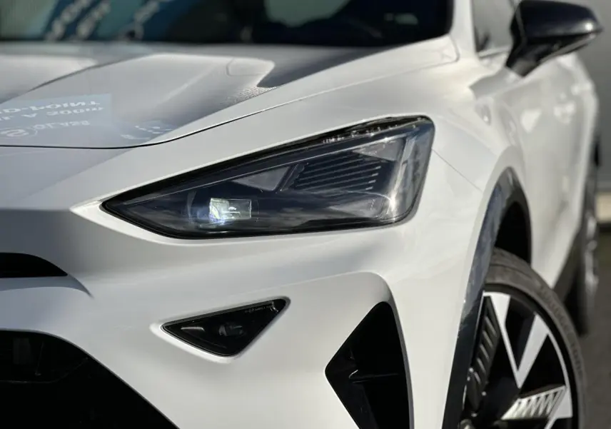 Gros plan sur l'avant droit blanc neige du CUPRA Formentor 2025, mettant en valeur son phare Tri-LED et jante alliage 19'' Sandstorm.