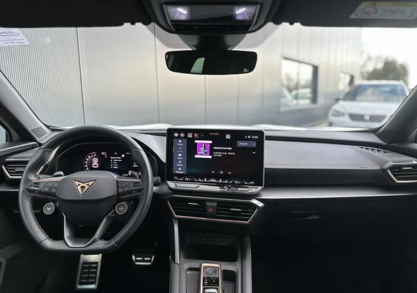 Vue intérieure avant du CUPRA Formentor blanc Neige 2025, tableau de bord moderne avec écran tactile et volant Supersports cuir.