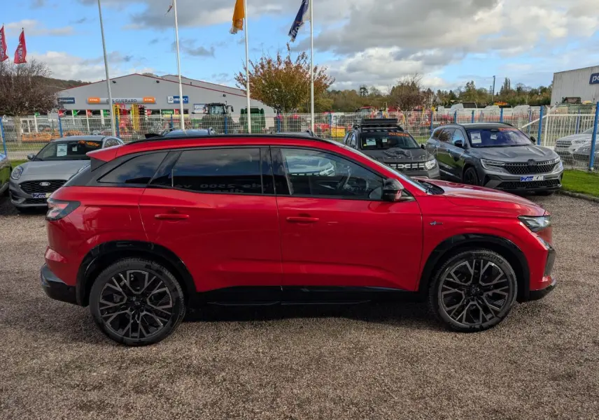 Profil côté gauche du Renault Austral rouge métallisé 2025 avec jantes alliage noires et toit panoramique.