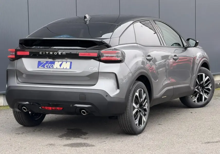 Vue 3/4 arrière droite d'une Citroën C4 gris Mercury avec toit noir Perla Nera et jantes alliage 18 pouces.