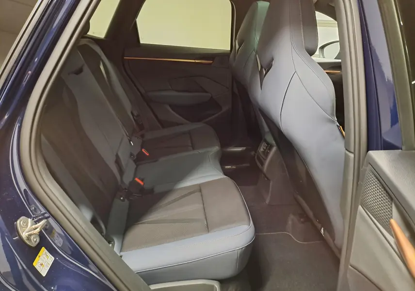 Vue intérieure côté gauche des sièges arrière en tissu et cuir gris d'un CUPRA TERRAMAR Bleu Cosmos 2025 avec portes ouvertes.